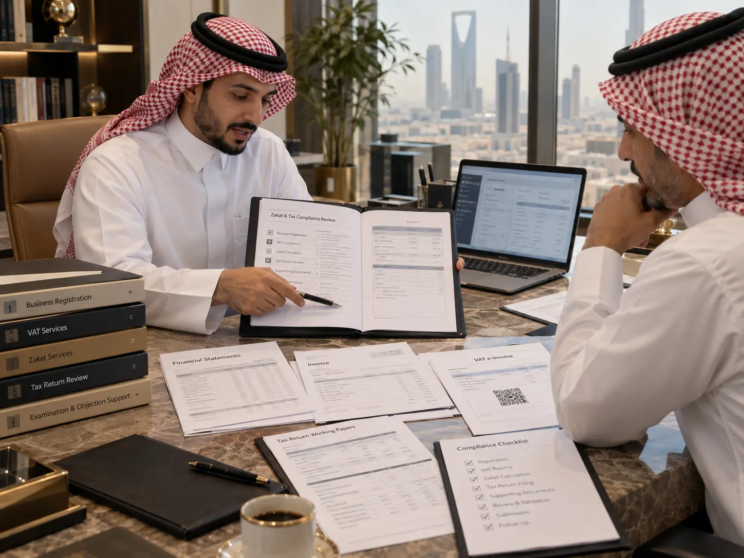 مستشار يراجع ملف الزكاة والضريبة مع صاحب منشأة في السعودية